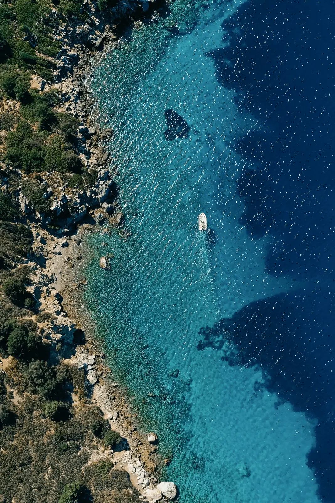 Aerial view of a vessel near a rocky coast